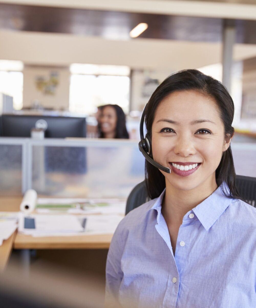 young-asian-woman-working-in-a-call-centre-smiling-H42VLBF-min